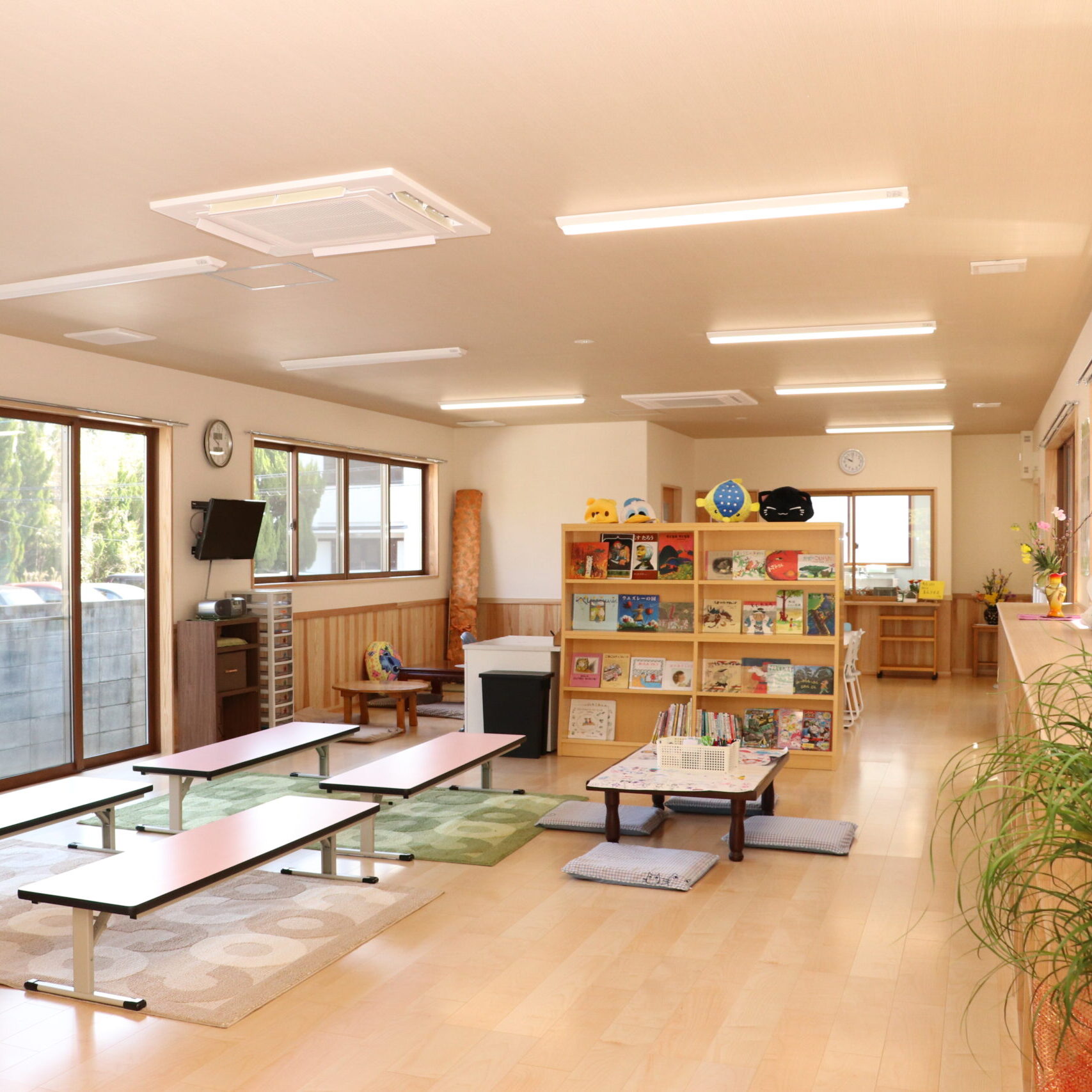 b＆gきつきの室内の様子。明るく広々とした室内には、子ども向けの本棚や座卓、クッションが並び、温かみのある木の内装が特徴的。